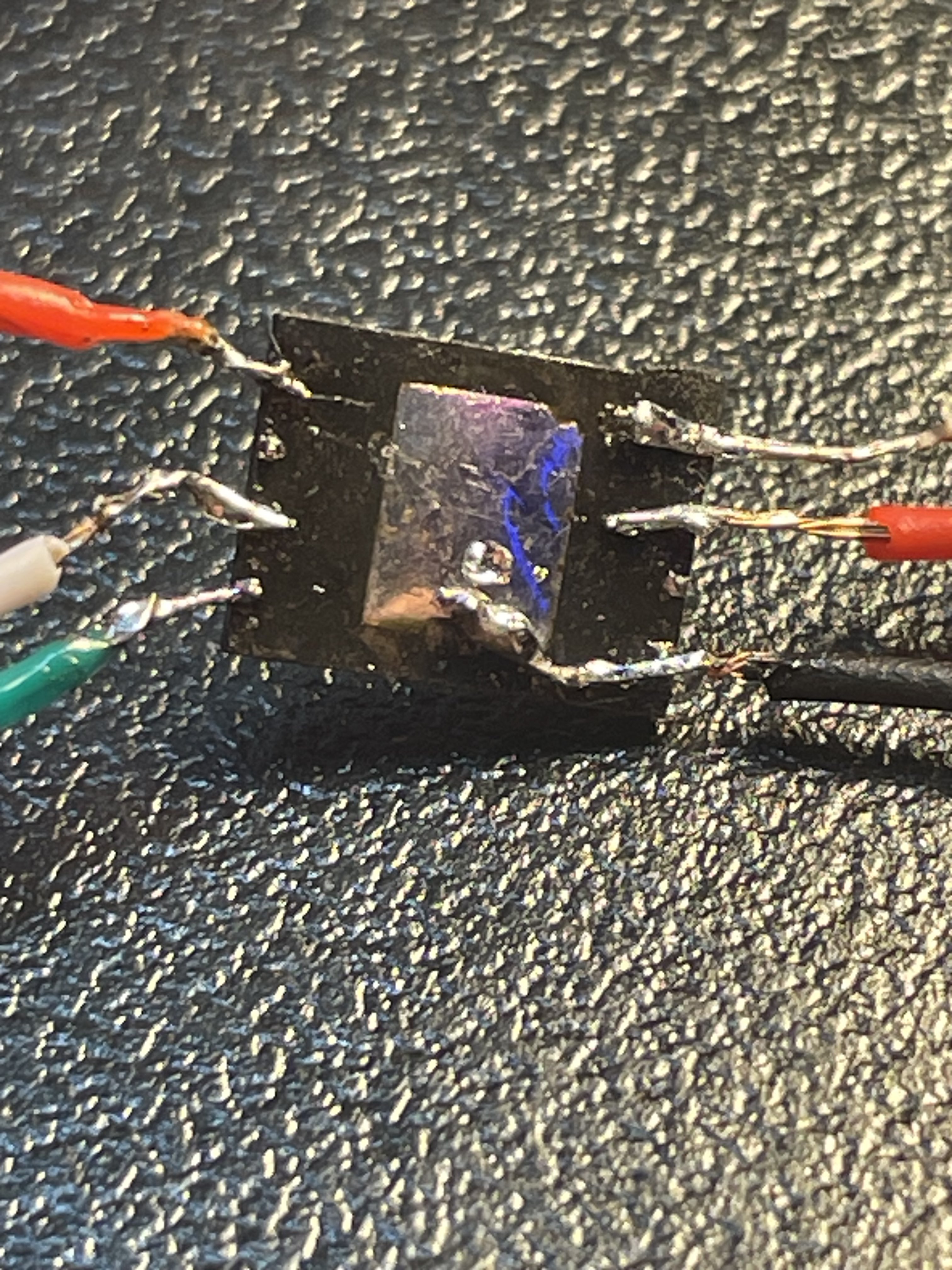 The flash chip with wires soldered to it.